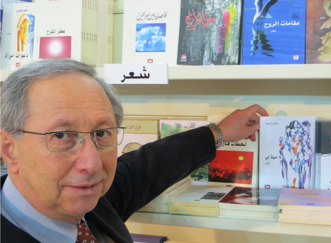 Iskandar El-Dick zeigt auf der Buchausstellung in Beirut 2013 auf seinen Gedichtband „لا حيلة لي